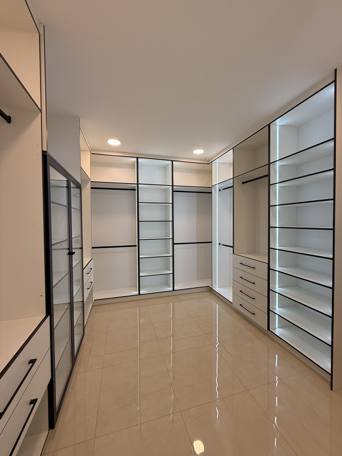 Vestidor con repisas, cajoneras y espacios para colgar.